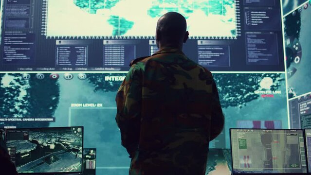 General of the army overseeing special reconnaissance mission in control center, undertake intelligence gathering operations with CCTV footage and a world map on a big screen. Camera B.