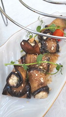 Fried eggplants with nuts, cheese on a white plate
