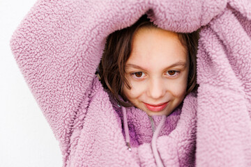 A child in a warm jacket.  portrait of a boy in a purple sweater with the hood pulled low over his eyes.