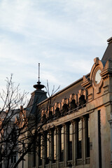Obraz premium A beautiful facade of a building with large windows, a spire and other architectural elements on which the setting sun falls, Tbilisi, Georgia.
