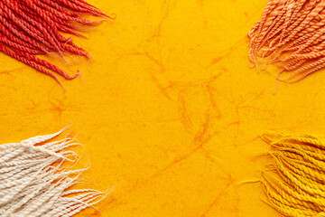 Top-view wallpaper of different colorful "Cotton Wicks", isolated on a orange textured background.
