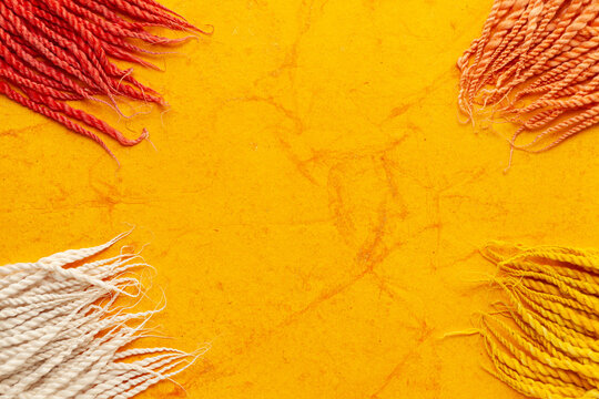 Top-view wallpaper of different colorful "Cotton Wicks", isolated on a orange textured background.
