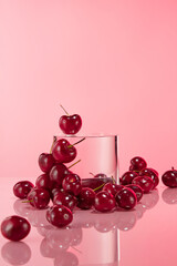 Plenty sweet cherries surround a circular platform in center, over pink background. Frontal shot photo has product displaying and advertising space
