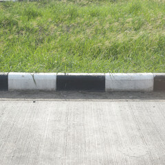 black and white curb road cement texture with green grass