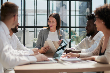 Employees working at computer together, discussing content