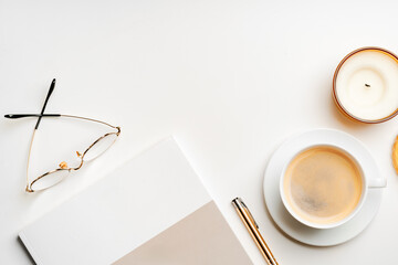 Blank paper, coffee cup and glasses on white desk