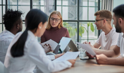 Obraz premium Team Working At Desks In Busy Office