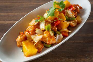 A view of a plate of sweet and sour chicken.