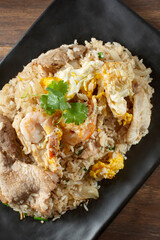 A top down view of a plate of fried rice, featuring pork and shrimp.