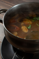 A view of a bowl of tom yum lemongrass soup.