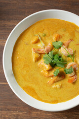 A top down view of yellow curry with shrimp.