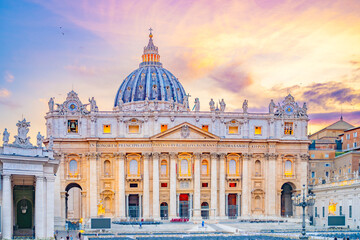 Obraz premium This image shows the front facade of St. Peters Basilica in Vatican City, Italy at sunset. The Basilica is bathed in warm golden light, highlighting its intricate