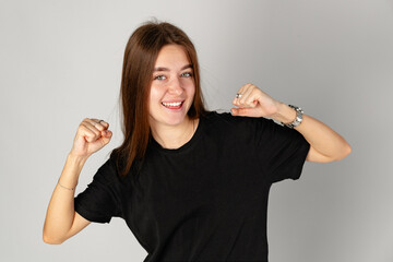 Young Woman Celebrating Success With a Joyful Gesture in a Studio