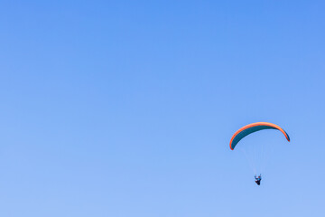 Paraglider flying alone at a blue sky