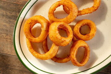A top down view of a plate of onion rings.