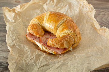 A view of a ham, egg and cheese croissant sandwich.
