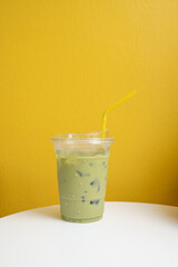 Green tea cup in yellow background