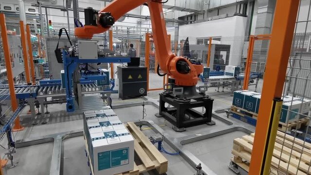  Robot palletizer orange KUKA robot kr180 stacks boxes on a pallet