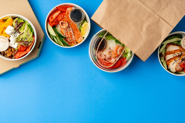 Different poke bowls on blue background top view