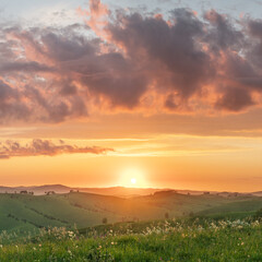 Evening rural landscape, the setting sun, sunset, meadows and hills