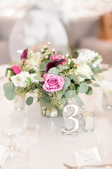 Elegant wedding centerpiece with roses and greenery on a table