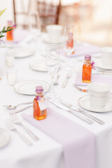 Elegantly set table with glassware, plates, cutlery, and small favors