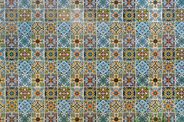 Close-up of a vibrant, intricate mosaic of colorful ceramic tiles, featuring geometric and floral patterns in various hues.