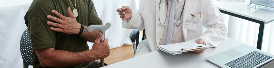 Header with soldier complaining on his injured arm to doctor