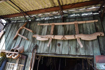 Various tools weigh on the wall of a wooden shed in the village