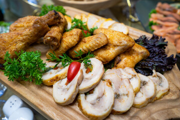 Meat plate. Chicken legs and wings with sliced ​​meatloaf garnished with lettuce.