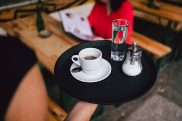 Bedienung serviert Kaffee auf Tablett