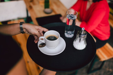 Bedienung serviert Kaffee auf Tablett
