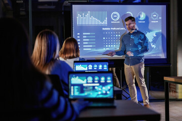 Fototapeta premium Helping to grow the company. Male business trainer is against projector with data, teaching people