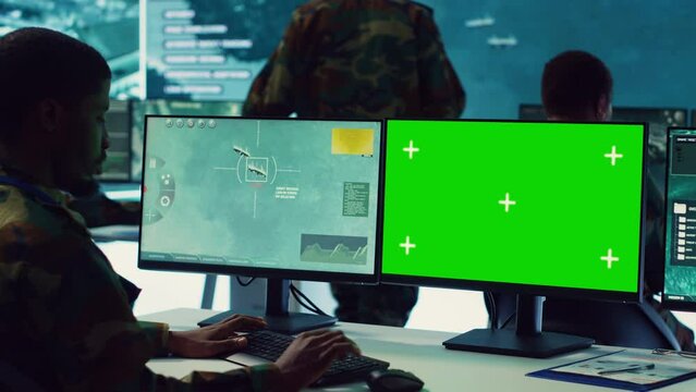 Private monitors national guard activity with military CCTV satellite system, working with a greenscreen display on pc in command center. IT reconnaissance operator tracking ships. Camera A.