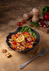 Rocca, beetroot, cherry tomato and pomegranate salad.
Healthy fresh fruit salad (rocket, orange, grapefruit, pomegranate, walnut) on black plate on dark background.