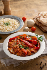 Chicken paprikash dish with paprika onion bulgarian paper with sauces and tomato.