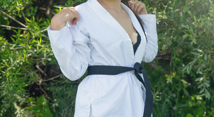 Caucasian woman in karate uniform at outdoor.