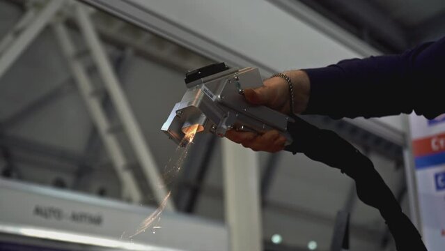 Laser removes rust on metal. Media. Hand gun with laser removes rust on metal. Laser with beam removes metal rust on parts