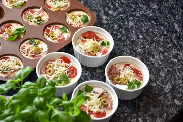 Pizza muffins with basil, olives, tomatoes