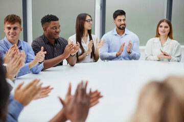 group of business people applauding sitting at the negotiating table