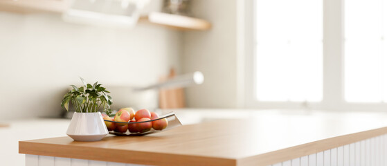 A close-up image of a wooden kitchen island with a copy space in a modern bright and clean kitchen.