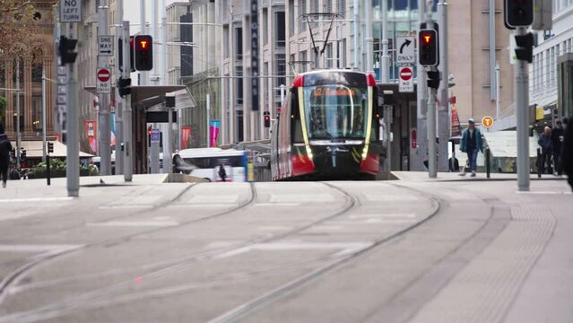 Timelapse of busy crowded pedestrian man and woman business people and tourist walking street crosswalk with traffic on the road and moving tram on tramway tracks at Sydney, Australia.