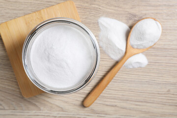 Baking soda in glass jar on wooden table, top view