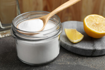 Baking soda and lemon on grey table, closeup