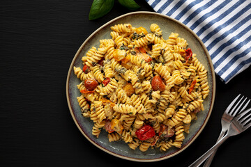 Homemade Baked Boursin Pasta on a Plate on a black background, top view. Flat lay, overhead, from above. Copy space.