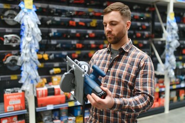 handsome young man shopping for tools at hardware store