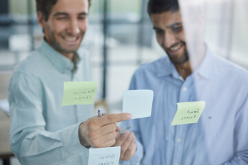 two successful businessmen in the office discuss a plan on stickers