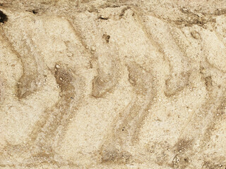 Traces from a tractor, car on the sand texture closeup. Tire tracks