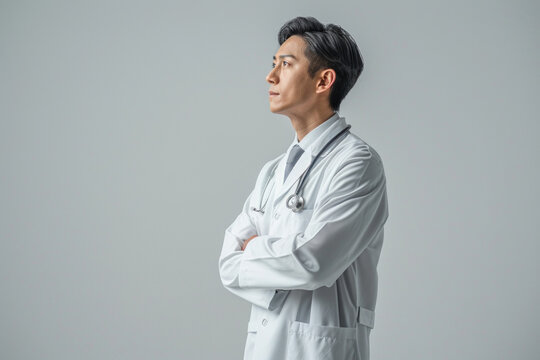 Professional doctor in white coat with stethoscope on white background