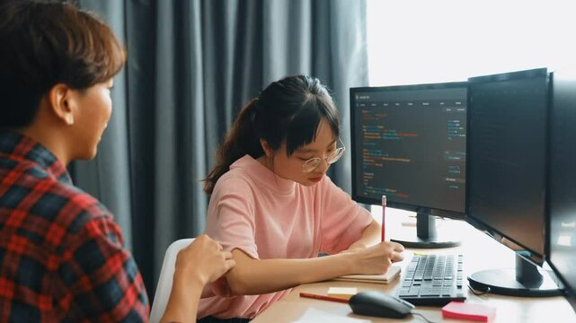Slow motion back end software developer engineer for computer programming working together on debugging writing computing code, solving complex algorithms display on monitor in office. Burgeoning